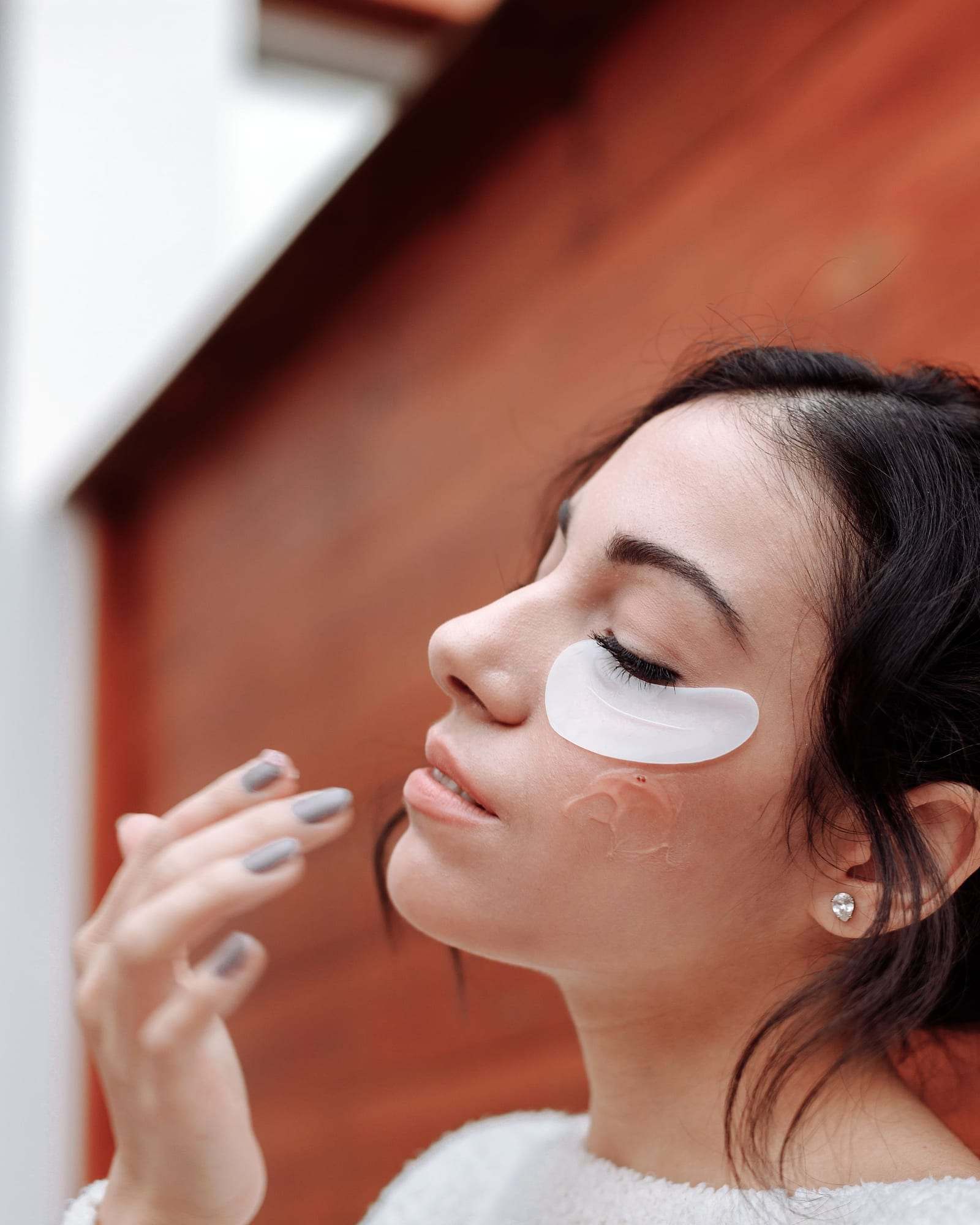 Woman with a hydrating under-eye patch during an eye contour treatment