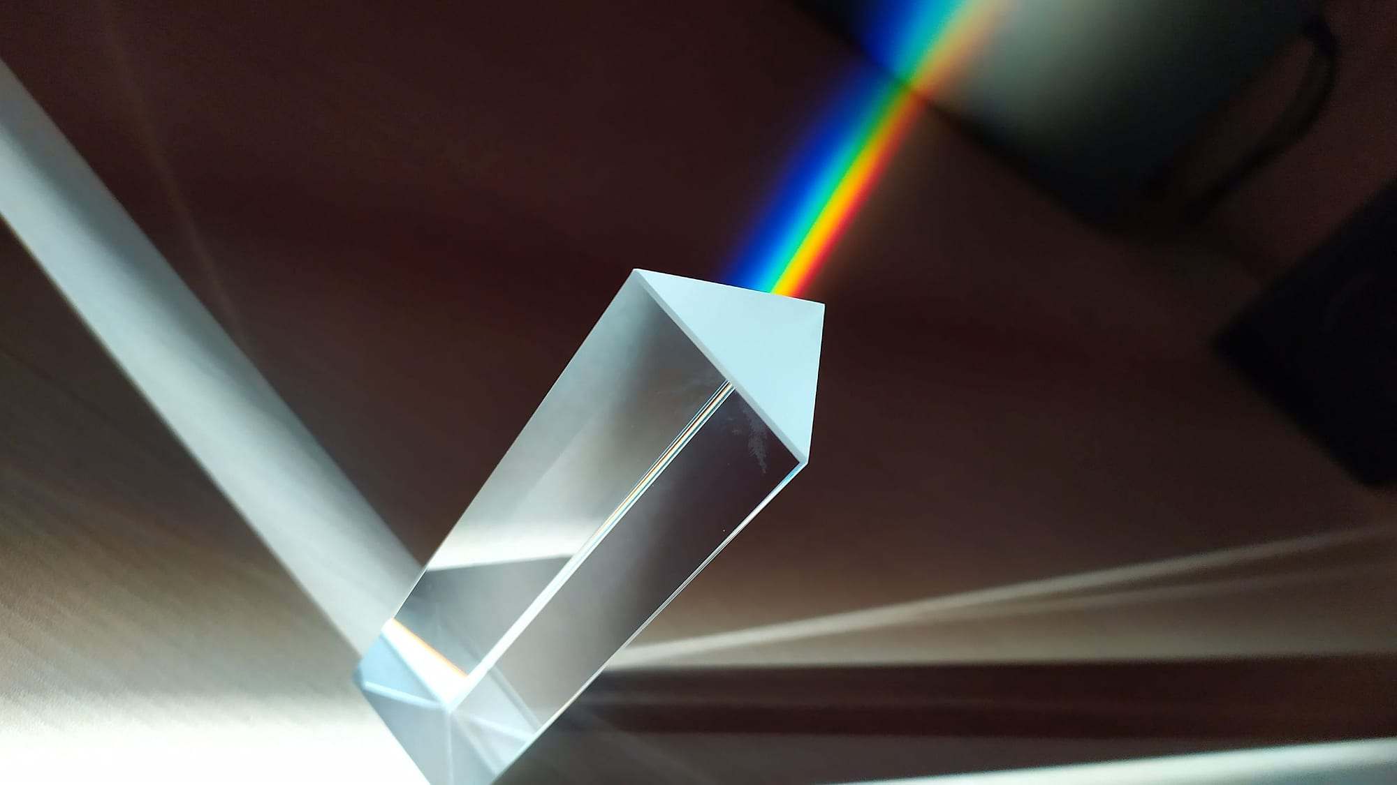 Prisma de cristal descomponiendo un haz de luz en un arcoíris