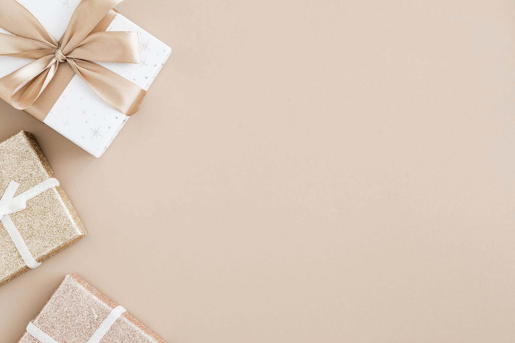 Cajas de regalo con lazos de raso sobre fondo beige