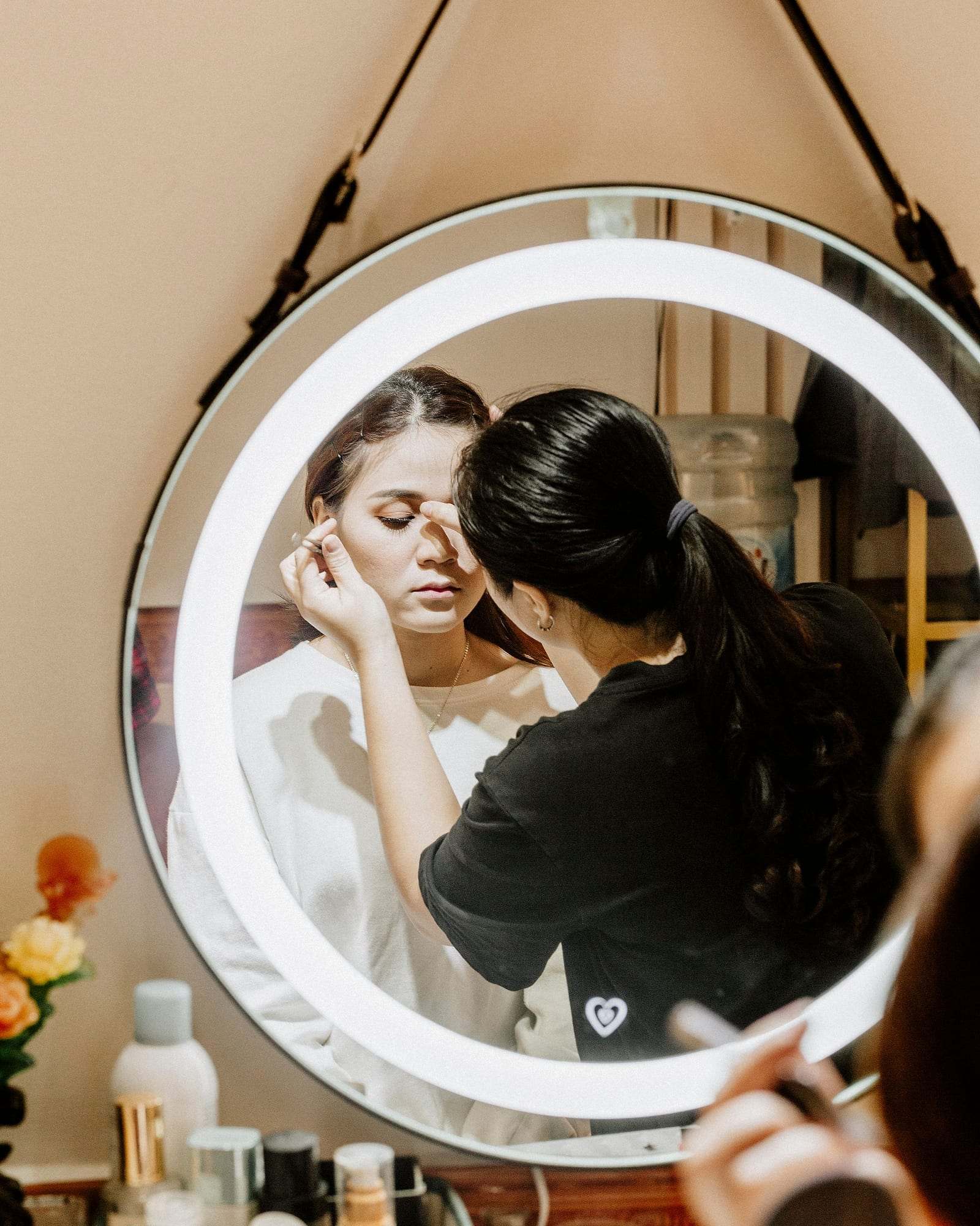 Maquilladora trabajando frente a un espejo iluminado