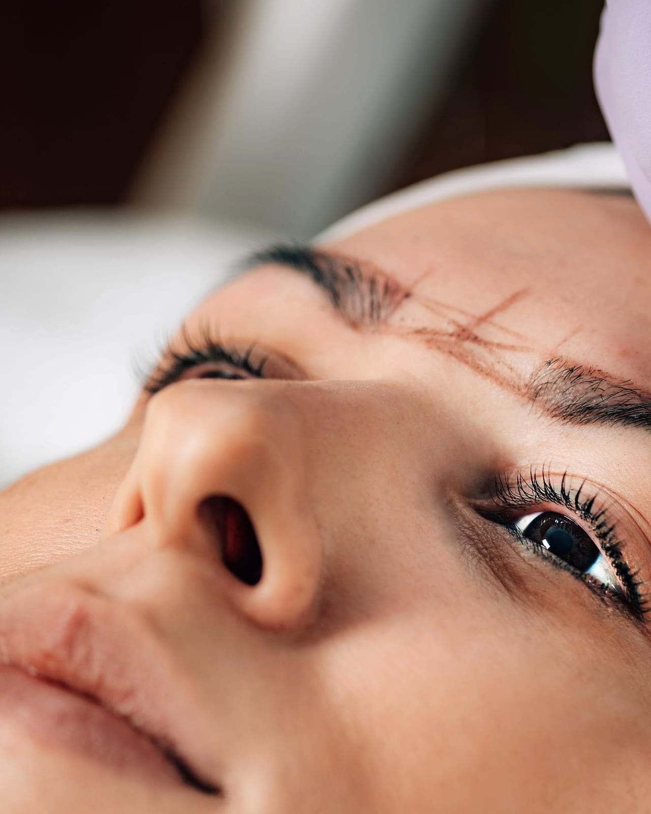 Eyebrow microblading: the artist draws hair-like strokes wearing gloves
